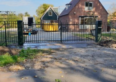 Dubbele draaipoort Adidas met brievenbus in zijstijl en naast poort hekwerk en hanankam vooraanzicht