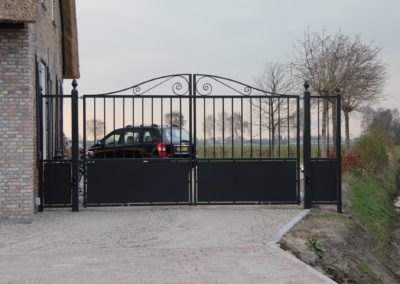 Dubbele draaipoort met onder dichte platen en bovenop een sierkrul met vaste zijstukken