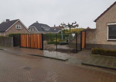 Dubbele en enkele draaipoort met houtvulling tussen gaashekwerk