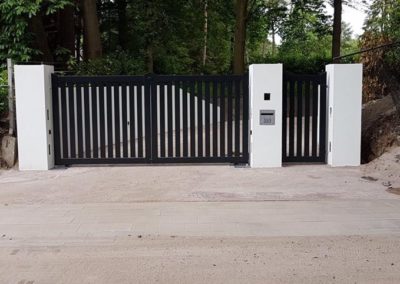 Dubbele spijlenpoort met brede spijl tussen kolommen met enkele poort