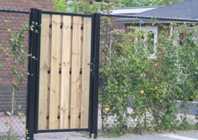 Enkele draaipoort met hout aan beide zijdes bekleed tussen gaas