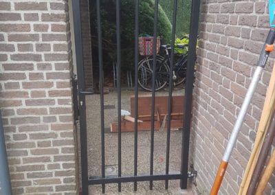 Enkele spijlenpoort tussen muur met muurbevestiging